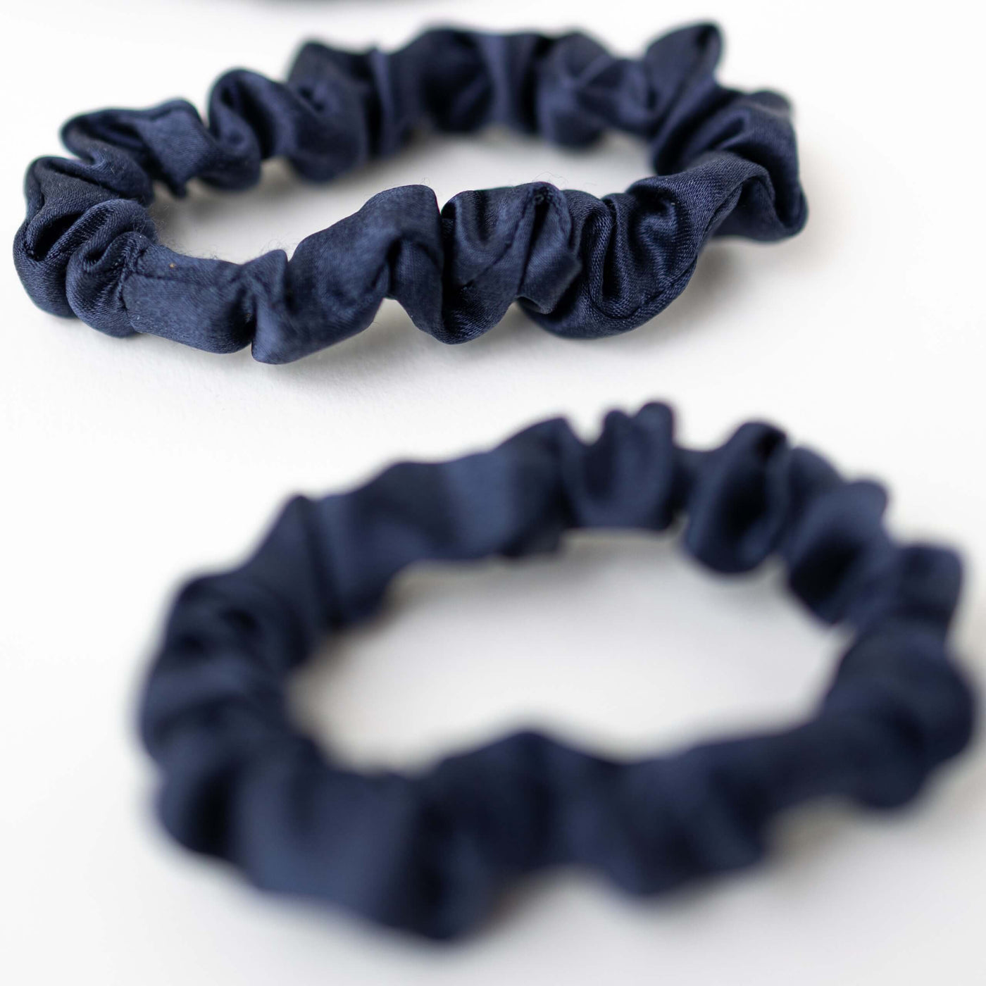 2er Bundle Mini Scrunchies von CURLY N COVERED aus reiner Maulbeerseide in Marine Blau auf weißem Hintergrund