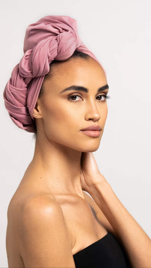 Wunderschöne Frau, die ein rosa Bambus Haar Handtuch von Curly'N'Covered als Turban trägt