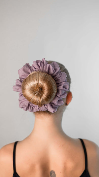 Wunderschöne Frau mit blonden Haaren trägt einen hell violetten XXL Scrunchie aus Cotton Silk (Baumwolle und Seide) von Curly N Covered im Haar.